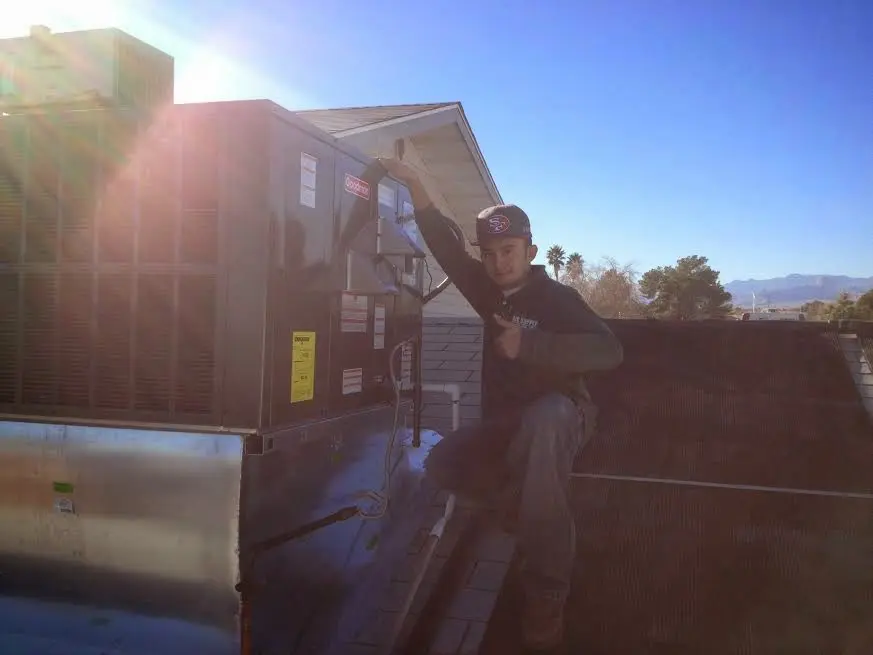 HVAC technician performing HVAC Inspection on a rooftop unit in Walworth